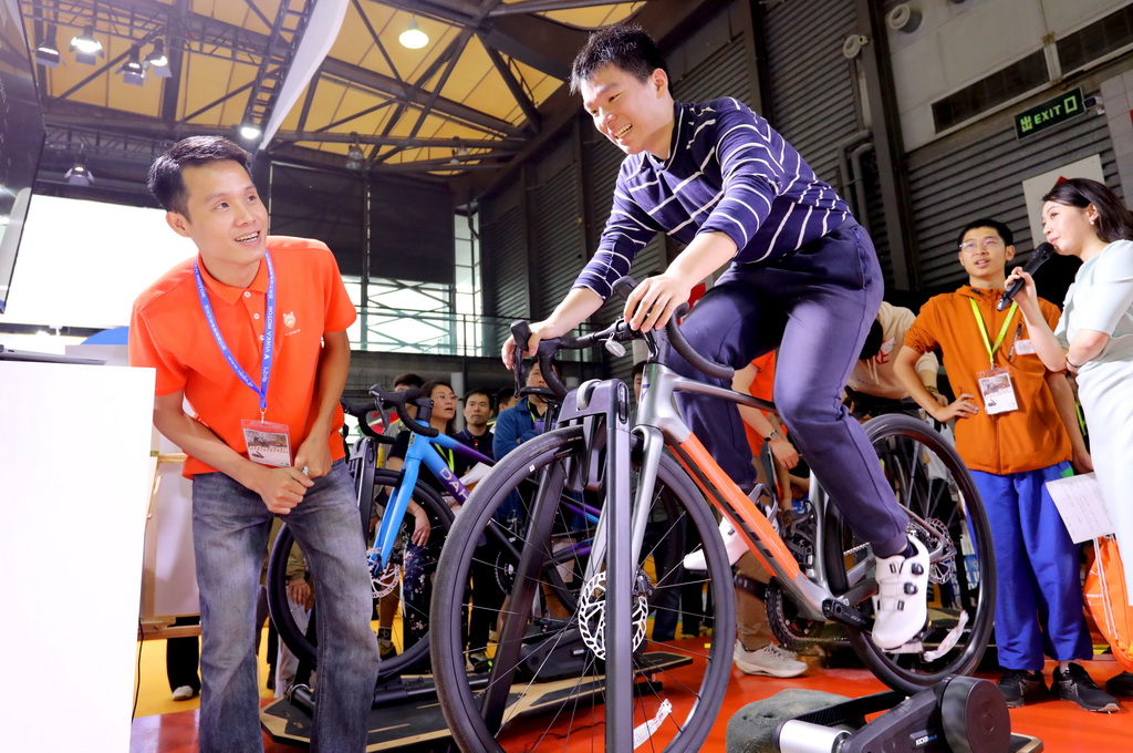 5月5日，一位参观者在展会现场体验骑行竞速游戏。新华社记者 方喆 摄